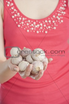 Young woman holding garlic in her hand