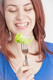 Young woman eating lettuce