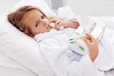 Little girl with bad cold - using nasal spray and paper napkins