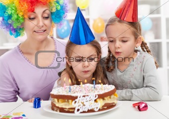 Birthday girl blowing out candles on a cake