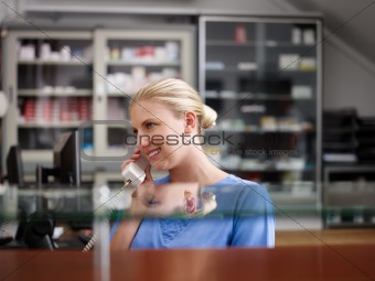 Woman working as nurse in clinic and speaking on telephone