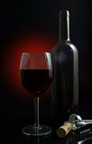 Glass of red wine with bottle