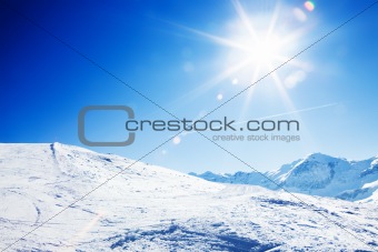 Sun over winter mountains, covered with snow