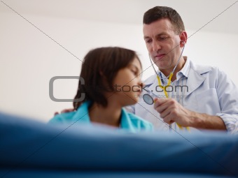 Doctor visiting sick young asian boy in hospital