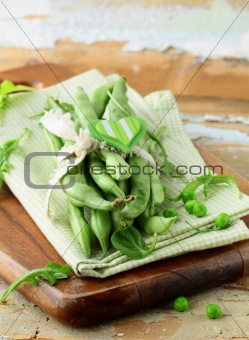 pods of green peas on a wooden table, rustic style