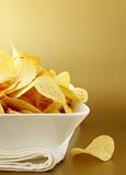 potato chips in a white bowl on a gold background