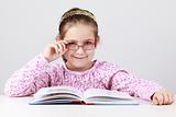 Schoolgirl with glasses reading book