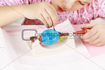 Child painting Easter eggs