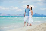 Happy young couple walking on a tropical beach