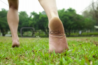 man's feet  running on the grass