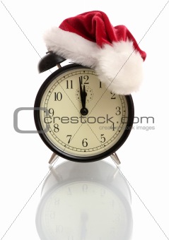 Black alarm clock in a New Year's cap on a white background