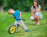 Little boy on a bicycle and his mother