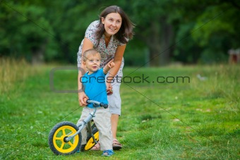 Little boy on a bicycle and his mother