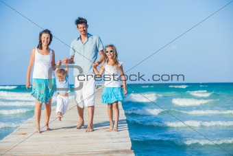 Family of four on jetty by the ocean