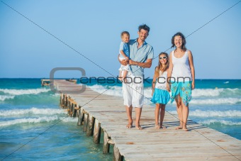 Family of four on jetty by the ocean