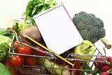 shopping list with pencil, basket and fresh vegetables