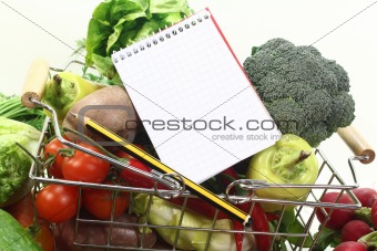 shopping list with pencil, basket and fresh vegetables