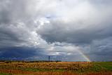 Clouds and rainbow above meadow