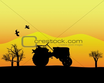 tractor in the background of trees and mountains
