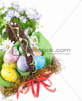 easter eggs in basket with spring flowers