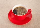 Black coffee in red cup with saucer