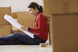 woman reading plans of new house during move