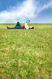 young man lying on the grass field and playing baseball