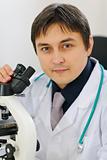 Portrait of male researcher working with microscope