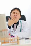 Tired medical doctor yawing