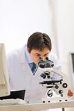Male researcher working with microscope in laboratory