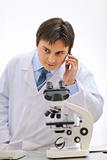 Male researcher speaking cellular in laboratory