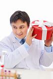 Happy medical doctor shaking present box trying to guess whats inside