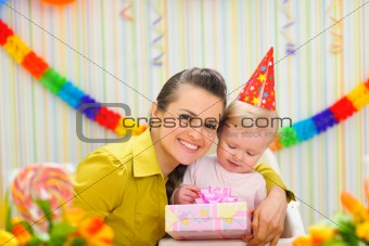Portrait of mother with baby celebrating first birthday