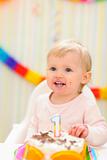 Portrait of eat smeared baby with birthday cake