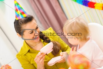 Mother having a tea on first birthday celebration of her baby