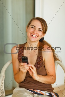 Portrait of smiling young woman with mobile phone