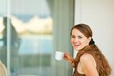 Happy young woman having cup of coffee