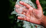 Fresh pure bubbling water splashing on hand