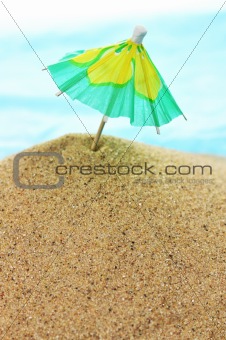cocktail umbrella on sand