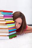 Young girl hiding behind books
