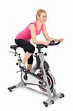 young woman doing indoor biking exercise, on white background