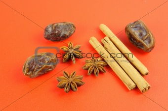 Christmas baking: Cinnamon, star anise, dates on red background