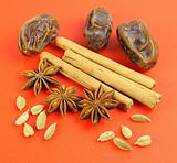 Winter flavors: Cardamom, Cinnamon, star anise, dates on red background