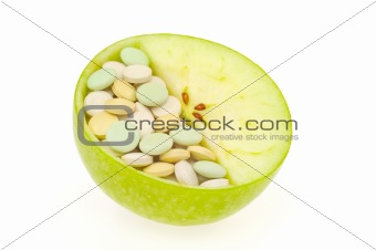 Close up of apple and pills isolated - vitamin concept