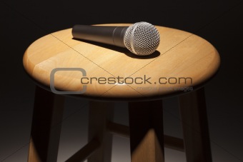 Microphone Laying on Wooden Stool Under Spotlight Abstract.