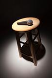 Microphone Laying on Wooden Stool Under Spotlight Abstract.