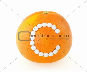 Grapefruit with vitamin c pills over white background - concept