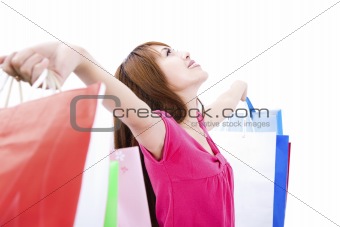 young woman holding shopping bag and looking up