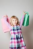 Little girl with shopping bags and lollipop