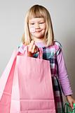 Little girl with shopping bags and lollipop